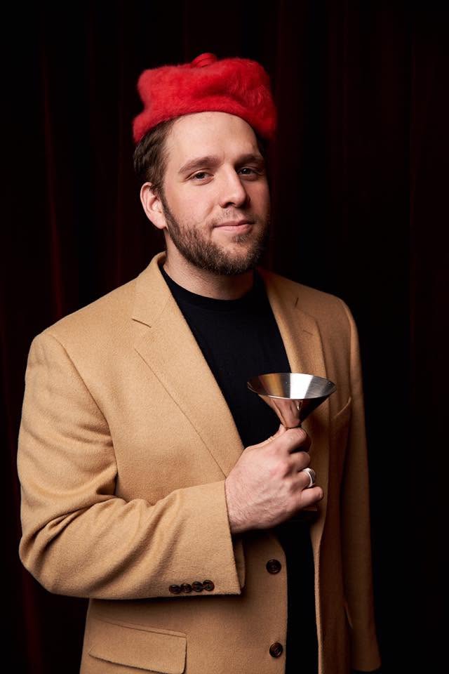 Brett Fink in a red hat and tan blazer